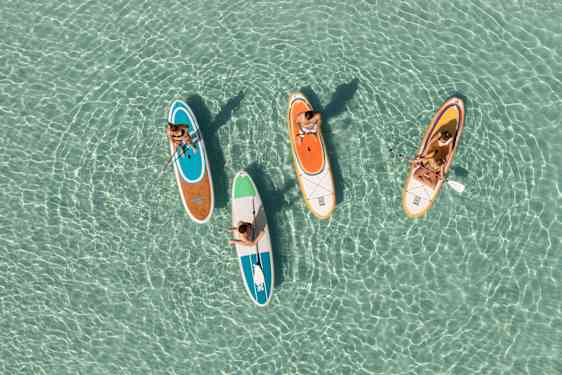 Värikkäitä SUP-lautoja kirkkaassa vedessä