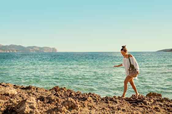 nainen kävelemässä rannalla