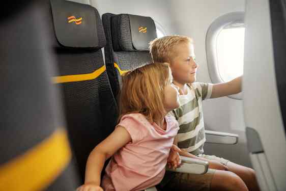 Kaksi lasta katsoo viihdeohjelmaa lentokoneen näytöltä.