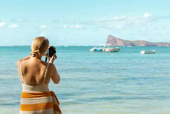 Lomaileva nainen valokuvaa saarta merellä.