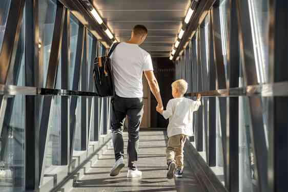 Isä ja pieni poika portilla menossa lentokoneeseen