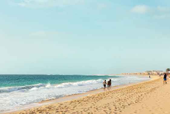Poika ja hevonen hiekkarannalla Kap Verdellä