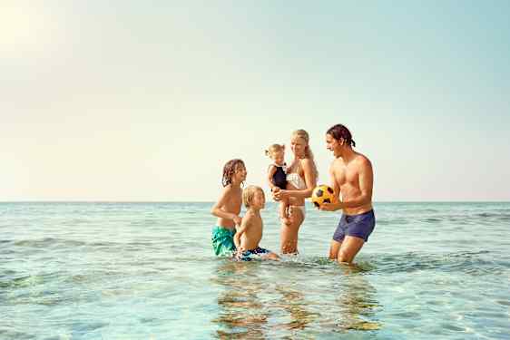 Perhe vesileikeissä rannalla