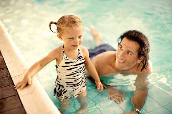 Pappa och dotter badar i en pool