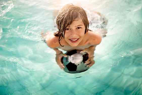 Poika uimassa pallon kanssa