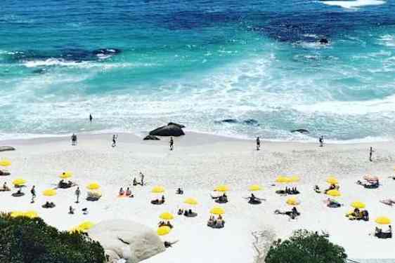 Clifton Beach, vaalea hiekkaranta aurinkovarjoisnen ja sinisen erisävyissä aaltoileva merisöder om Kapstaden.