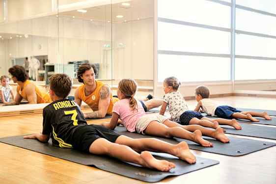 Lapset ohjaajan kanssa liikuntatunnilla