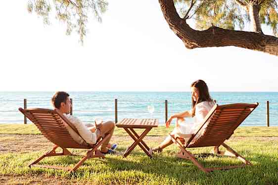 Mies ja nainen hotellin terassilla aurinkotuoleissa