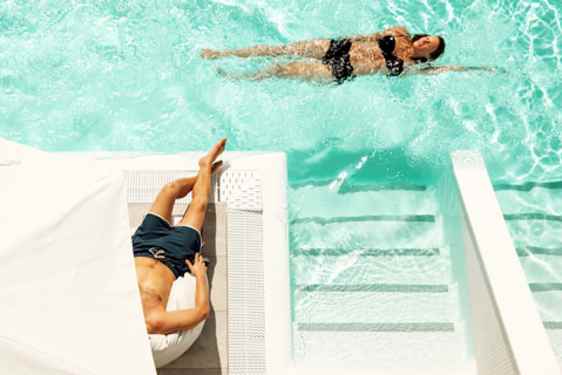 Mies ja nainen uima-altaalla OBC-hotellissa