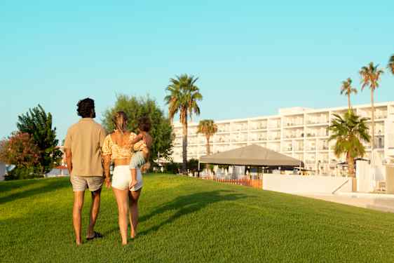 Perhe kävelee nurmikolla