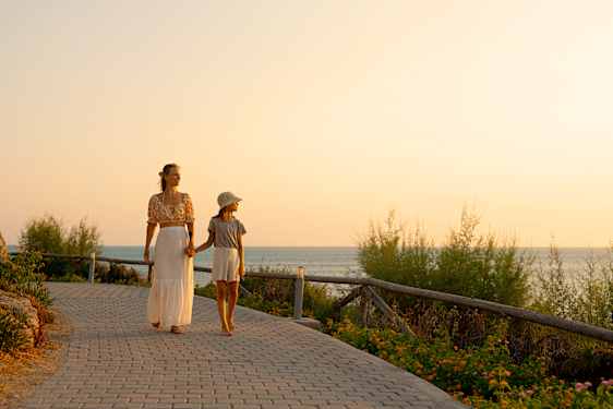 Mor og datter går tur i solnedgangen