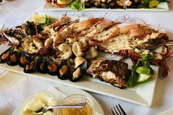 Kaksi isoa ruokalutasta täynnä erilaisia äyriäisiä.