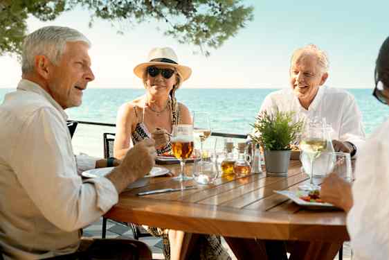 Kaksi pariskuntaa ruokailemassa rantaravintolassa