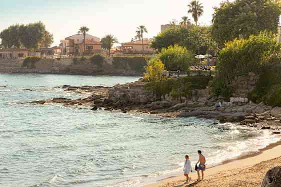 Pari kävelemässä hiekkarannalla