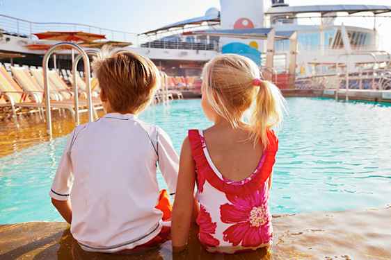 Kaksi lasta istuu risteilyaluksen uima-altaan reunalla