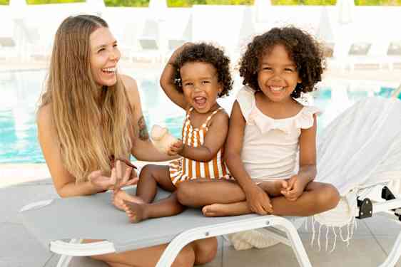 Nainen kahden lapsen kanssa uima-altaalla