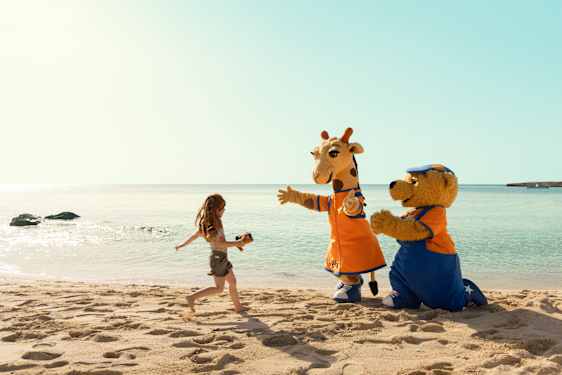 Tyttö juoksee Lollon & Bernien luokse rannalla