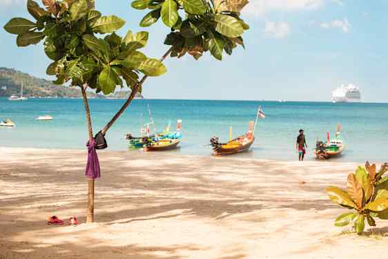 Patong Beachin rantaa, vedessä muutama vesiskootteri ja pitkähäntävene, taustalla ulompana risteilyalus.