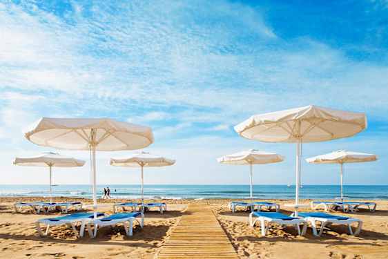 Aurinkotuolit ja -varjot hiekkarannalla