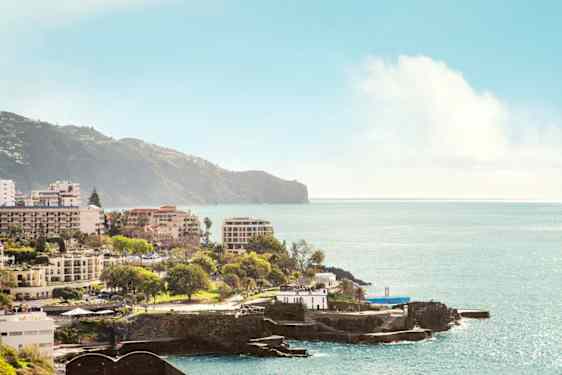 nainen joogaamassa rannalla auringon laskiessa