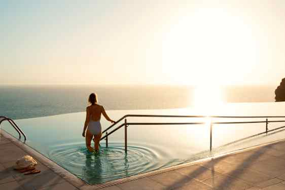 Nainen kävelee infinity pool -altaaseen.