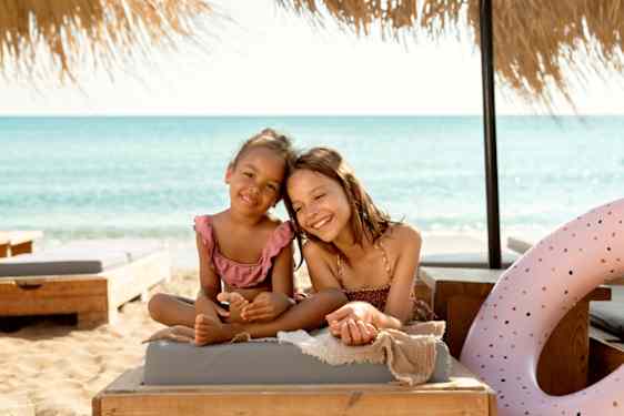 Kaksi lasta taurinkotuolissa rannalla