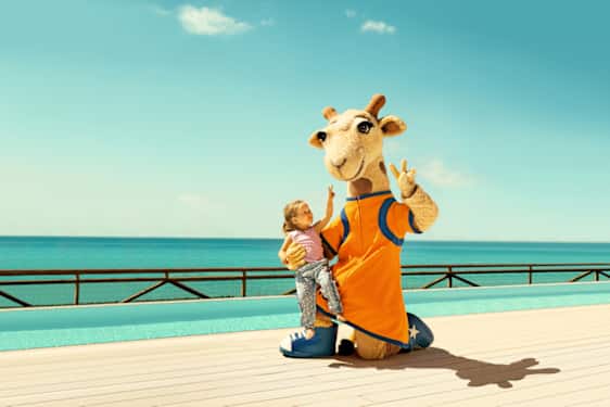 Tjäreborgin maskotti Lollo-kirahvi lapsi sylissään.