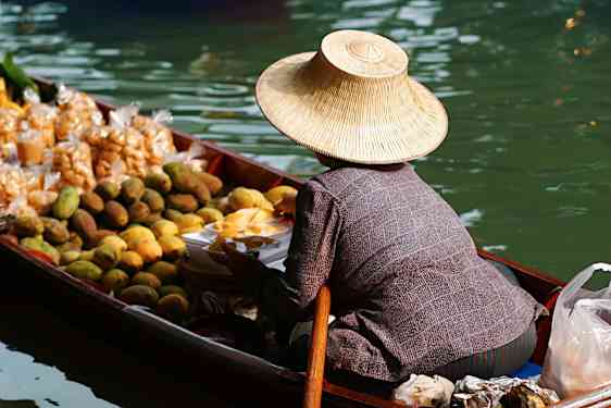 Nainen jolla on veneessään myynnissä hedelmiä