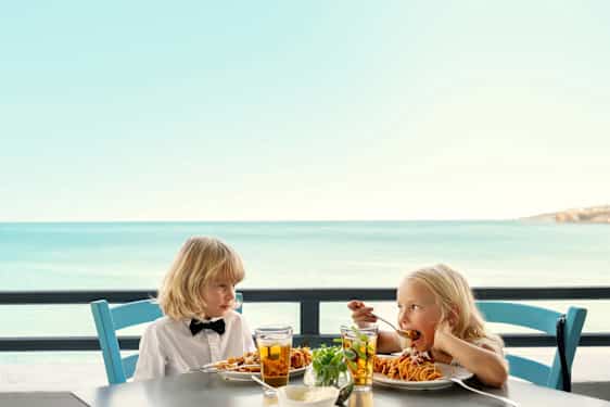 Kaksi lasta ruokapöydän ääressä