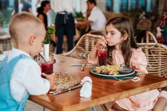 Lapset pöydän ääressä ruokailemassa
