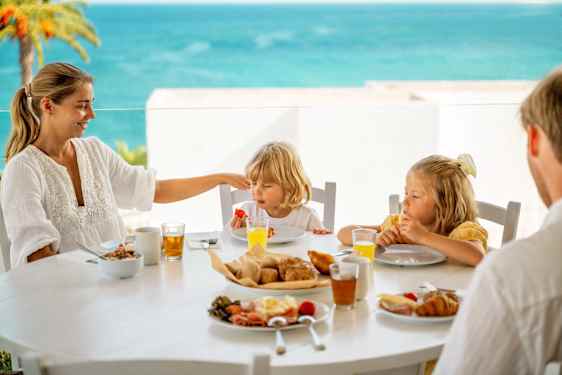 Perhe yhdessä syömässä