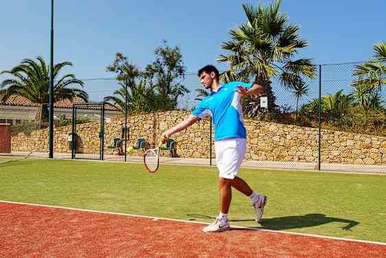 Mies pelaamassa tennistä