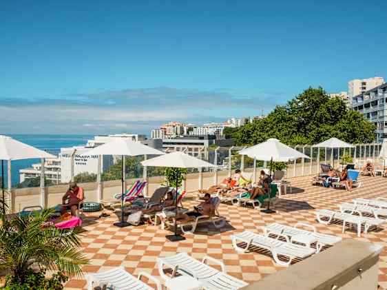 Aurinkotuoleja allasalueella