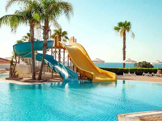 Sunwing Kallithea Beach -hotellin uima-allas ja kaksi vesiliukumäkeä.