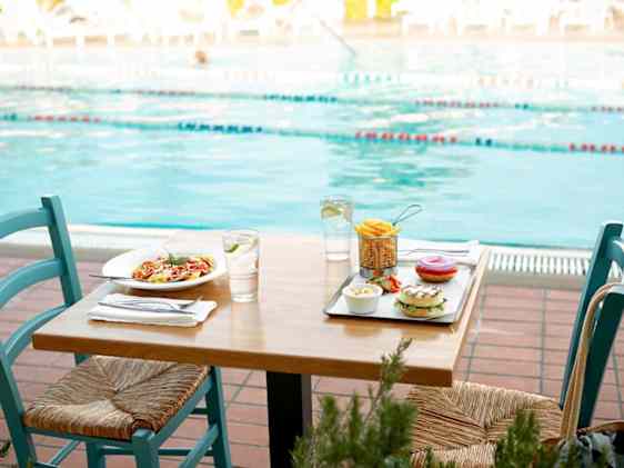 Lounas katettuna pöydälle altaan vierellä