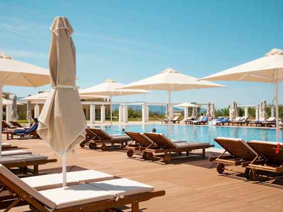 Aurinkopetejä allasalueen ympärillä Ilion Beach -hotellissa.