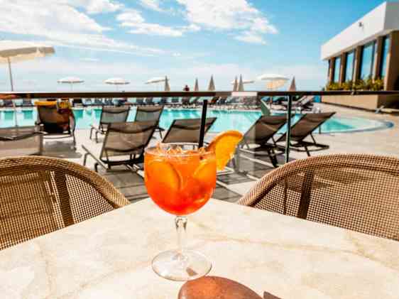 Aperol Spritz lasillinen Duas Torres -hotellin allasbaarin pöydällä.