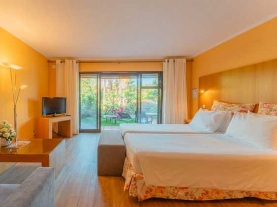 Yksiö, rajoitettu merinäköala -huonetyypin makuuhuone, josta näkymä terassille ja puutarhaan