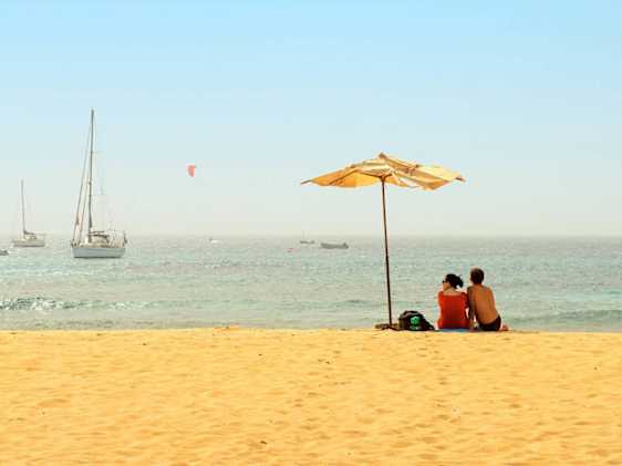 Nainen joogaamassa hiekkarannalla