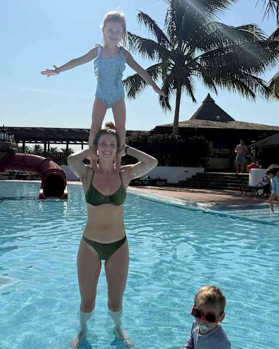 Äiti ja tytär leikkivät uima-altaassa