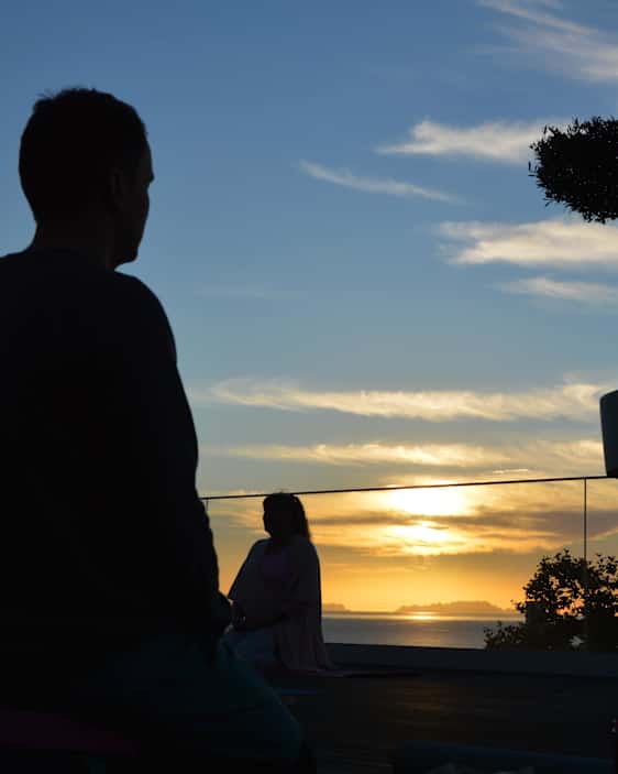 Joogaajat aamunsarastuksessa kattoterassilla