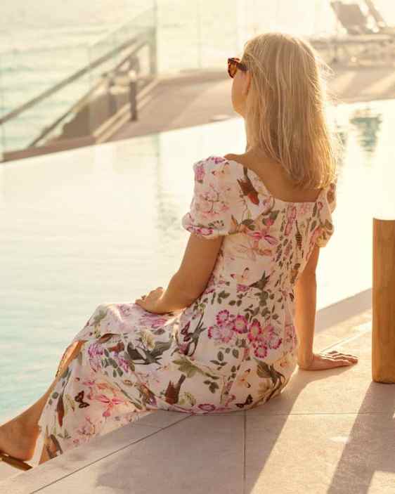 Nainen istumassa selin kameraan altaan reunalla