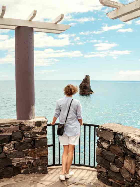 Nainen näköalapaikalla katsomassa merta
