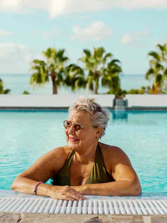 Nainen uima-altaan reunalla