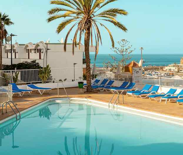 Ulkouima-allas, jota ympäröivät aurinkotuolit, merinäköalalla ja palmujen ympäröimänä. (Tekoälyn luoma teksti)