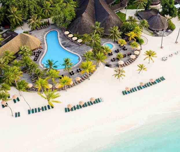 Ilmakuva rannasta, jossa on aurinkotuoleja, varjoja ja uima-allas palmujen ympäröimänä. (Tekoälyn luoma teksti)