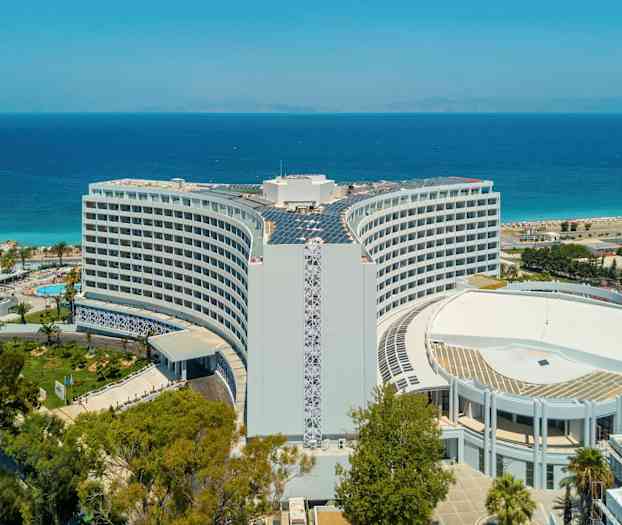 Hotelli, taustalla meri ja ranta. (Tekoälyn luoma teksti)