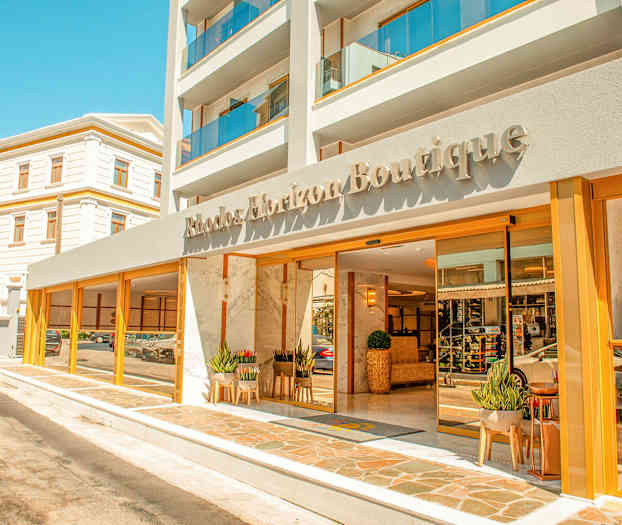 Hotellin etupuoli, jonka nimi on Rhodos Horizon Boutique; sisäänkäynnillä on lasiovia ja kasveja. (Tekoälyn luoma teksti)