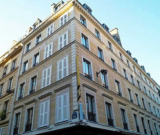 Kulmatalo, jossa on useita kerroksia ja ikkunaluukut. (Tekoälyn luoma teksti)