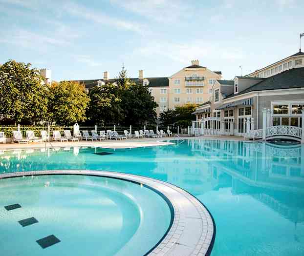 Ulkoallas, jota ympäröivät aurinkotuolit, rakennukset ja puut. (Tekoälyn luoma teksti)